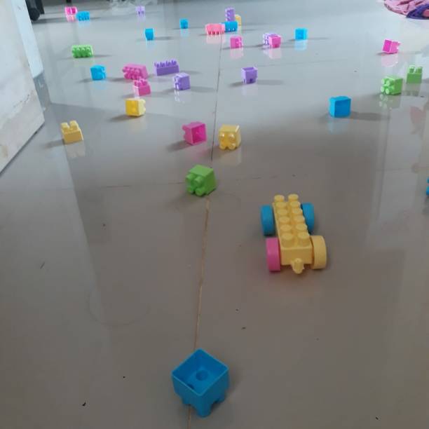 Lots of colorful Legos scattered on the gray floor