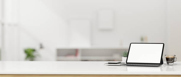 istock Tablet mockup with wireless keyboard and empty space on tabletop over blurred office in background 1407425511