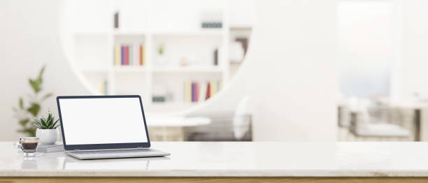 istock Workspace with laptop mockup and copy space on white tabletop over blurred coffee shop 1407425537
