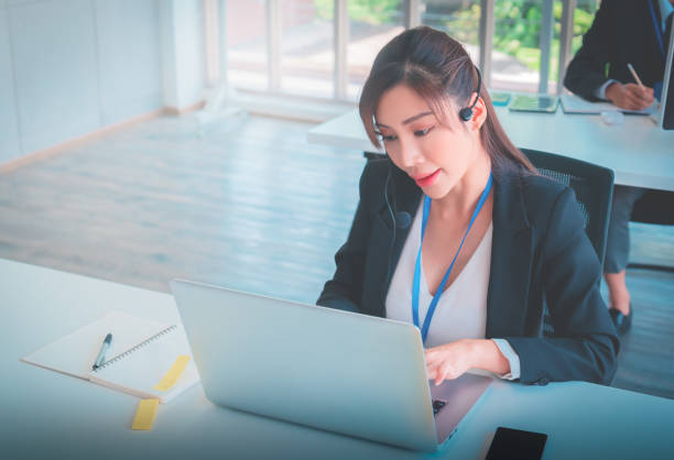 istock Asian female customer service is answering call on headphone in an operator service office. 1407430077