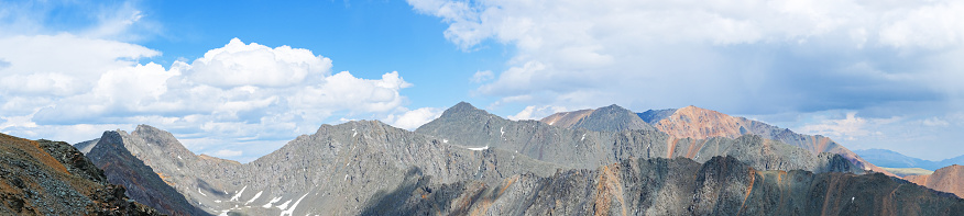 Beautiful panoramic landscape of rocky mountains among the clouds, banner format.