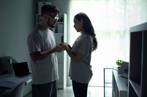Young Asian couple holding hands and making up after a fight. Young Asian couple holding hands and making up after a fight. Husband and wife try to solve relationship problem and getting back together after an argument. asian husband angry stock pictures, royalty-free photos & images