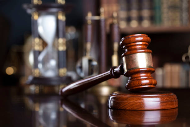 Judge office. Gavel and scale on the judge desk. Book shelf  in the background. court room stock pictures, royalty-free photos & images