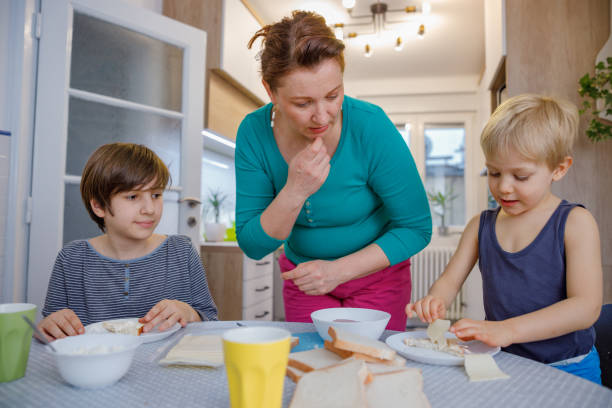 istock Mother looking at her sons eating breakfast at the dining table at home 1407445662