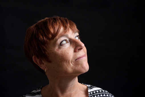 face of middle-aged woman on black background