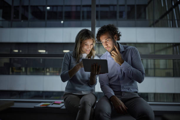istock Young business colleagues working on touchpad late in the office. 1407446022
