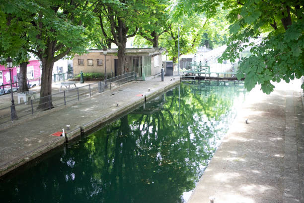 istock Sunlight shining through the trees around canal lock gates 1407446966