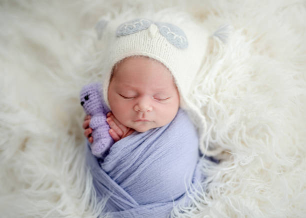 istock Newborn with toy in tiny hands 1407447349