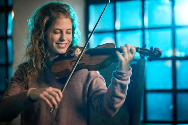 mujer feliz tocando el violín. - violinista fotografías e imágenes de stock