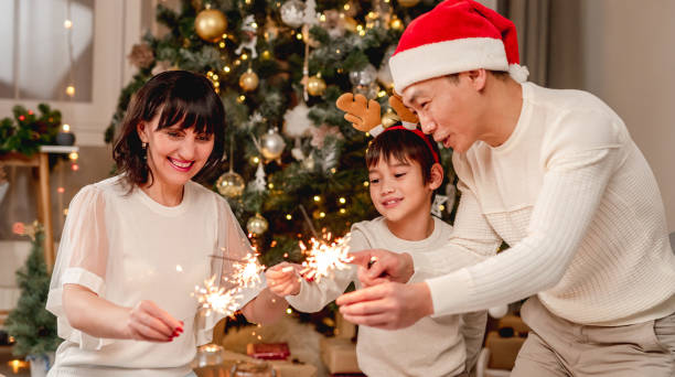 istock Happy family with sparklers under christmas tree 1407448571