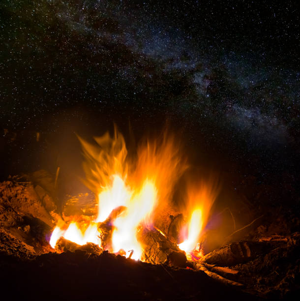 istock closeup camp fire at the night under starry sky 1407449206