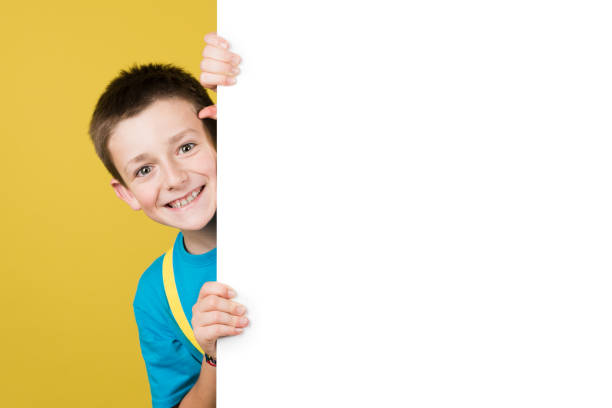 istock Cheerful boy hidden behind white billboard 1407449375