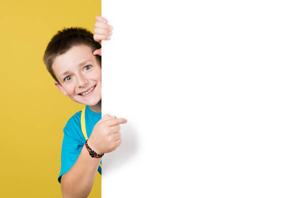 istock Smiling boy pointing at white copy space at the side 1407449376