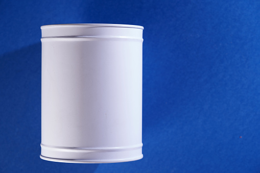 top view of white saving coin box against blue background