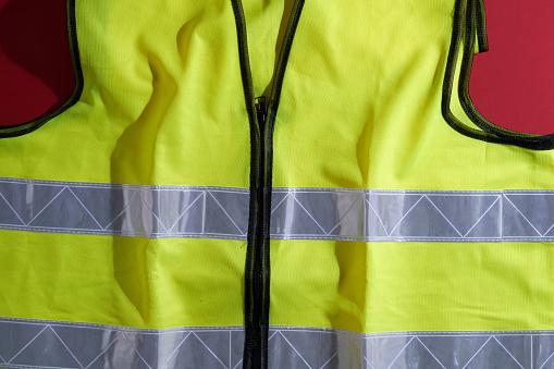 Yellow reflective vest against red background