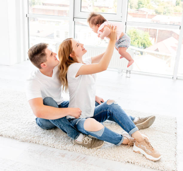 istock Parents holding up baby 1407450002