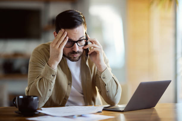 istock Worried businessman having a phone call while working at home office. 1407451931