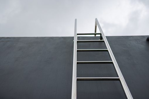 stainless steel ladder to the rooftop. outdoor service ladder of building.