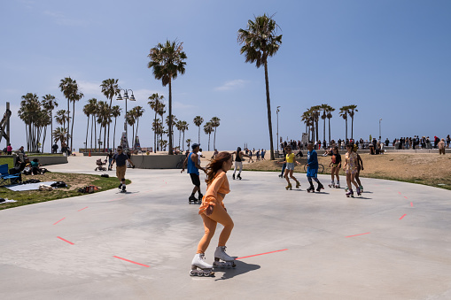 Los Angeles, USA - May 8th, 2022: People roller-skating on Venice Beach late in the day.