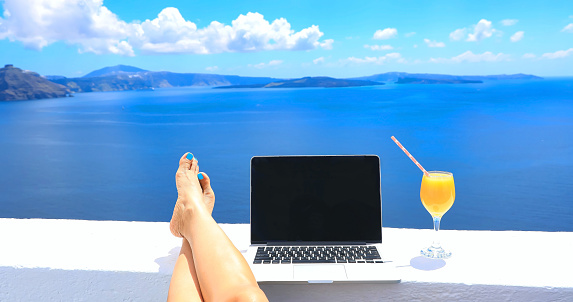Relaxation lifestyle with nomad digital woman freelancer as running remotely with bright scenic view of the Mediterranean Sea ,Oia -Santorini,Greece
