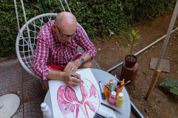 istock Senior man using black pen to outline art poster elements 1407461845