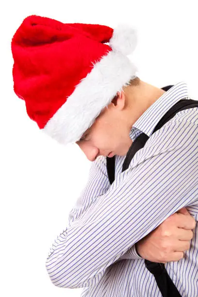 Sad Teenager in Santa Hat on the White Background