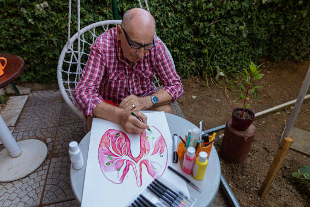 istock Senior man using black pen to outline art poster elements 1407461864