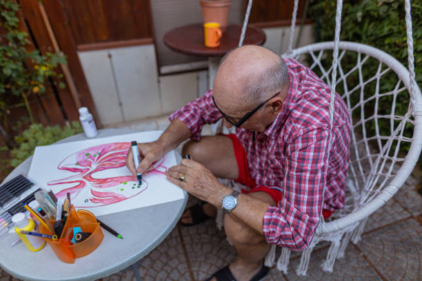 istock Senior man using black pen to outline art poster elements 1407461906