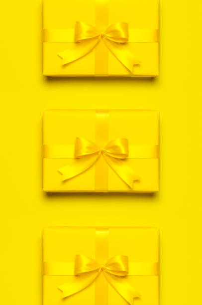 istock Holiday pattern. Yellow gift box with ribbon and bow on bright yellow background flat lay top view. Surprise, gift for birthday, mother's day, March 8, Christmas, anniversary. Congratulation 1407462848