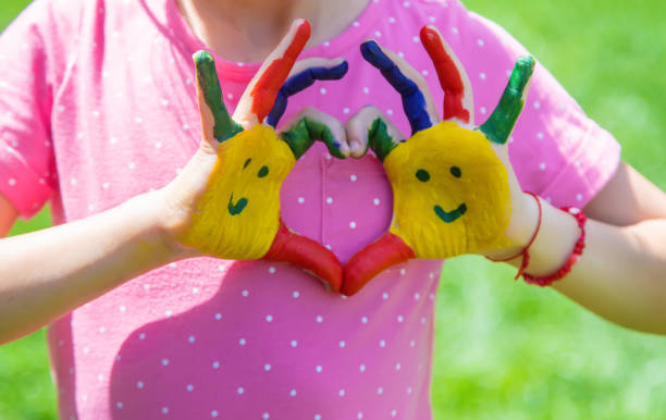 istock Hands of a child with a painted smile. Selective focus. 1407463092