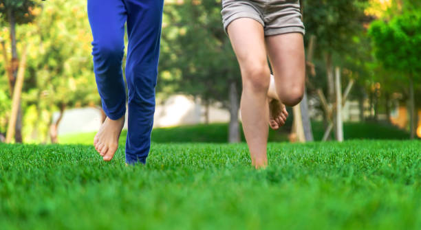 istock Children's feet go on the grass. Selective focus. 1407463128