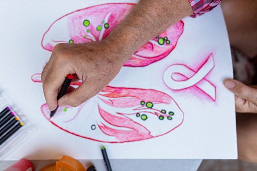 Retired man joining an art project where they have a task to make a poster about lung cancer