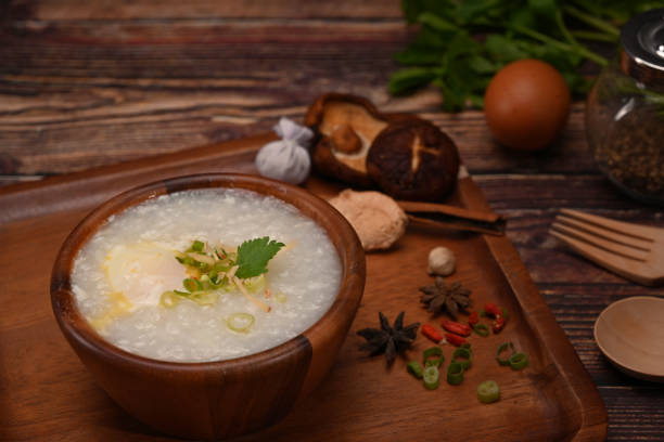 istock Rice porridge with boiled egg ,sliced ginger and slice scallion on wooden table. Congee is a type of rice porridge popular in many Asian countries. 1407464522