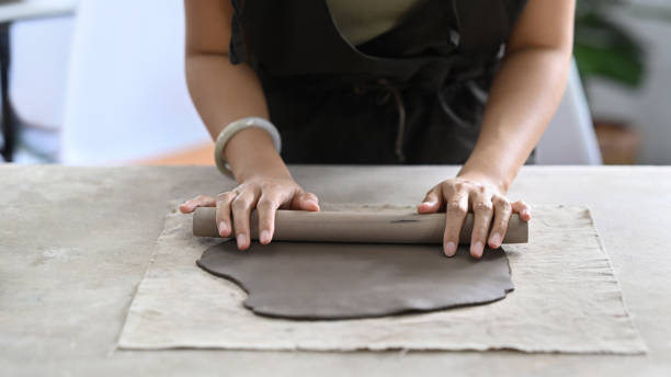 istock Young woman creating handmade ceramic bowl in workshop. Indoors lifestyle activity, handicraft, hobbies concept. 1407464928