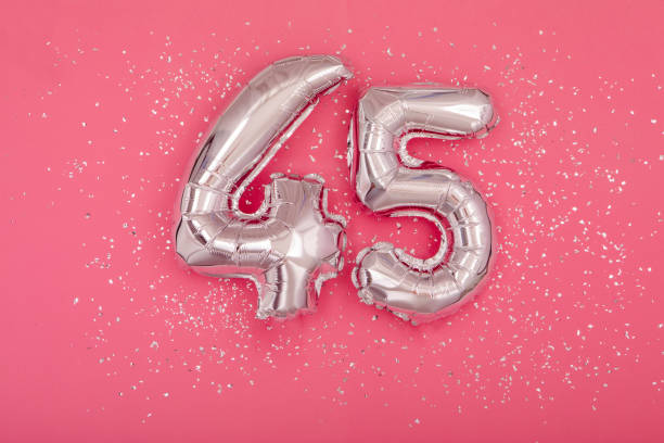 istock Silver balloon shape of number fourty five 45 pink background 1407468825