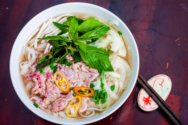 Pho Bo vietnamese soup with beef and rice noodles on a table, close-up. Local restaurant in Vietnam. stock photo