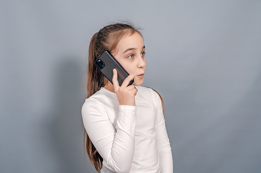 Cute girl with mobile phone. Girl is talking on mobile phone. Communication.