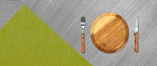 Topview of Set of Plate, Fork and Knife on Abstract Green Background