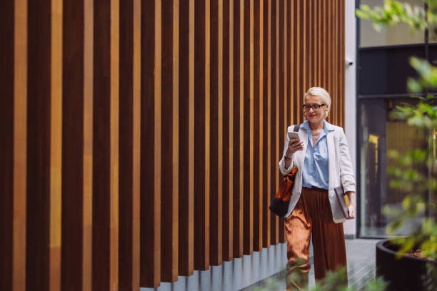 mulher de negócios sorridente usando telefone celular ao ar livre - people office mobility looking - fotografias e filmes do acervo