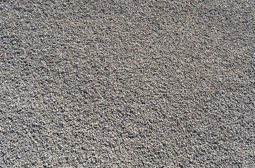 Crushed stone. Small gray stones. Abstract texture. Building material