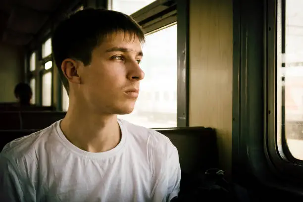 Toned Photo of Pensive Young Man sit in the Train