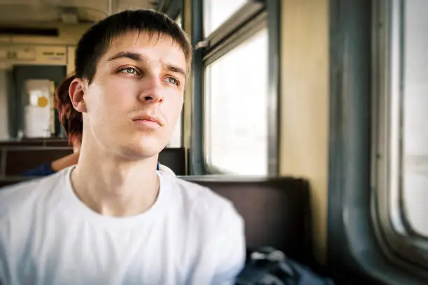 Sad Young Man sit in the Train by the Window