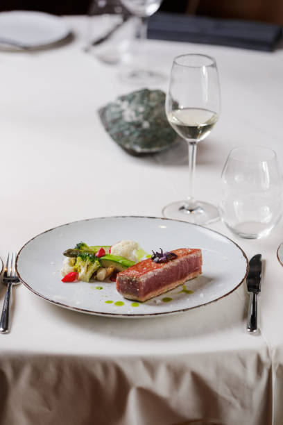 istock Salmon serving with vegetable garnish on plate in fine dining 1407475417