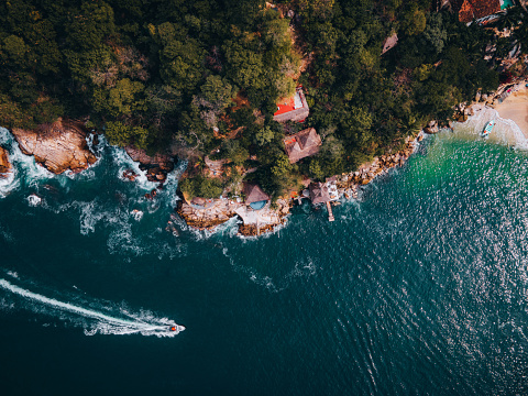 Drone point of view on a beautiful secluded, empty beach with turquoise water in a small bay, Jalisco , Puerto Vallarta, Mexico.