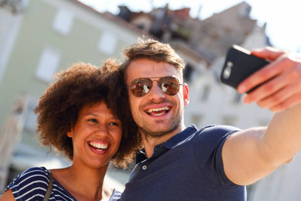 istock Mixed race couple taking selfies 1407477536