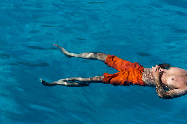 istock Man floating in the blue sea 1407477811