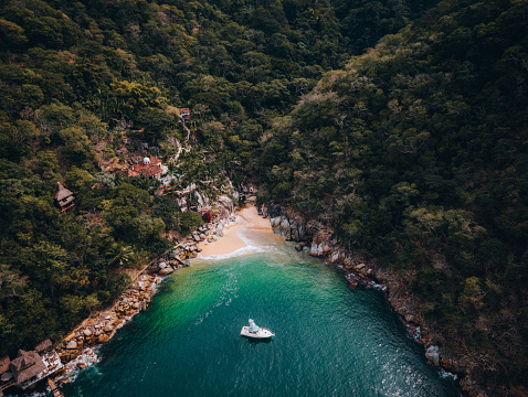 Drone point of view on a beautiful secluded, empty beach with turquoise water in a small bay, Jalisco , Puerto Vallarta, Mexico.