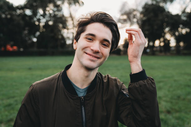 istock Young adult man looking at camera while he's fixing his hair 1407480196