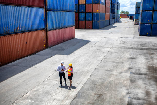 istock Business Logistics concept, Foreman control loading Containers box of cargo freight ship for Logistic planning. Industrial worker works with co-worker at overseas shipping container yard . 1407486971