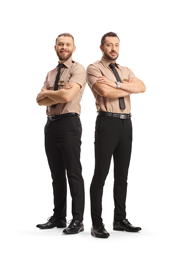 Full length portrait of two security guards posing with crossed arms isolated on white background